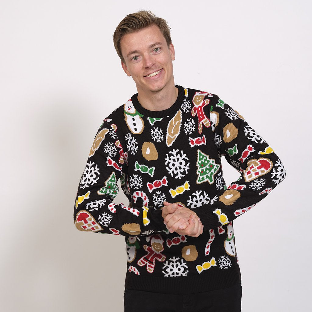 Un homme portant un pull noir avec des décorations de Noël.